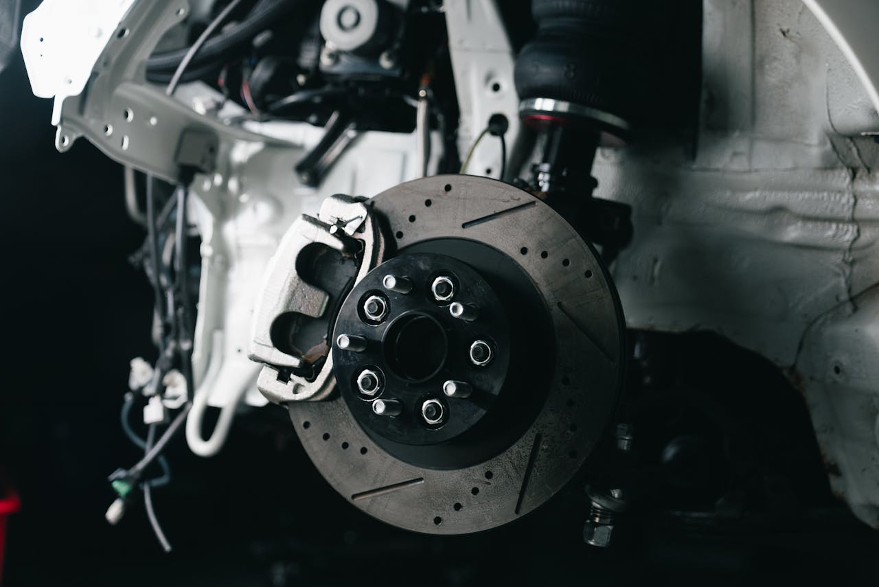 Detailed view of a vehicle's disc brake system with caliper, showcasing automotive technology.